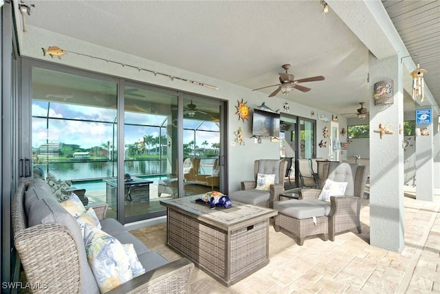 view of patio with a water view, an outdoor living space, and ceiling fan