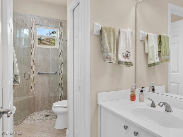 bathroom featuring toilet, walk in shower, vanity, and tile patterned flooring