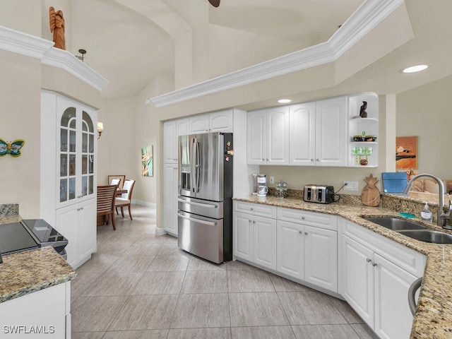 kitchen featuring crown molding, sink, stainless steel fridge, white cabinets, and light stone counters