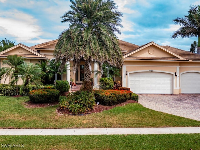 view of front of property featuring a front lawn and a garage