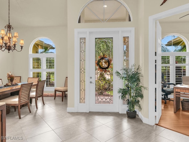 doorway featuring an inviting chandelier and light tile patterned floors