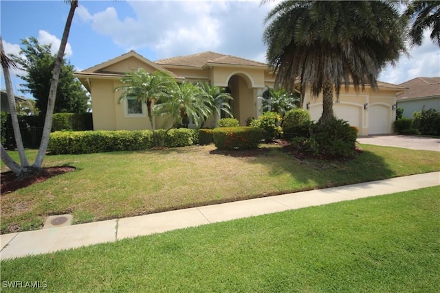 680 Thrush Ct, Marco Island, FL 34145 - mediterranean / spanish home with an attached garage, concrete driveway, stucco siding, and a front yard
