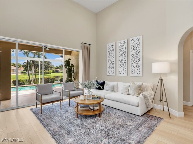 living room featuring hardwood / wood-style flooring and a towering ceiling