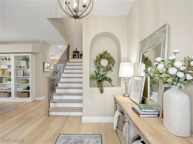 entryway featuring an inviting chandelier and light hardwood / wood-style flooring