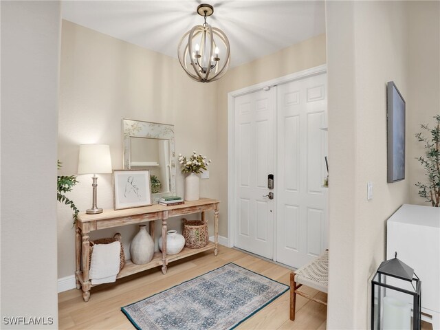 foyer entrance featuring hardwood / wood-style floors and an inviting chandelier