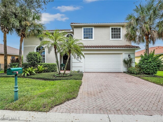 mediterranean / spanish house featuring a front yard and a garage