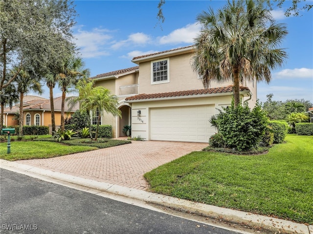 mediterranean / spanish-style home featuring a front yard and a garage