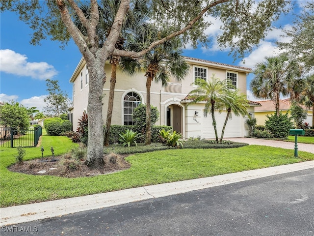 mediterranean / spanish-style house with a garage and a front lawn