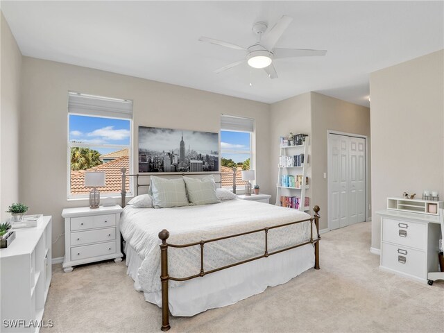 carpeted bedroom with ceiling fan and a closet