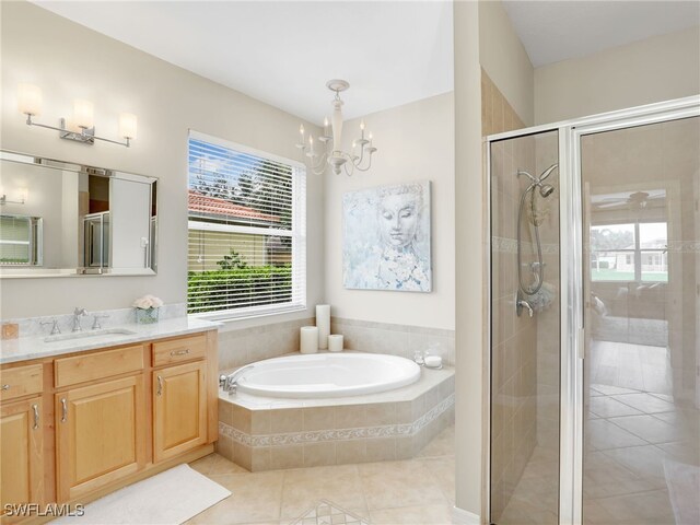 bathroom featuring an inviting chandelier, tile patterned floors, vanity, and separate shower and tub