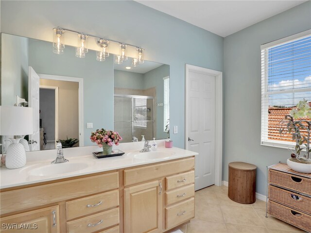 bathroom with vanity, a shower with shower door, and tile patterned floors