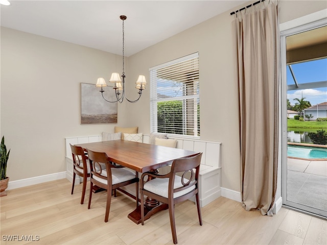 dining area with light hardwood / wood-style flooring and a notable chandelier