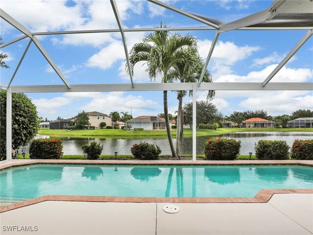 view of pool with a lanai, a water view, and a patio area