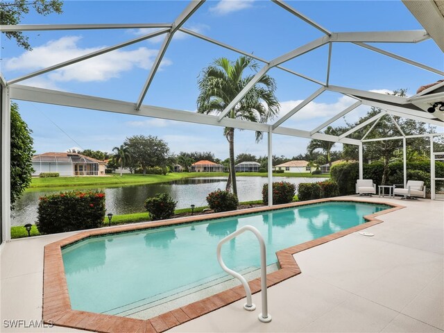 view of pool featuring a lanai, a water view, and a patio area