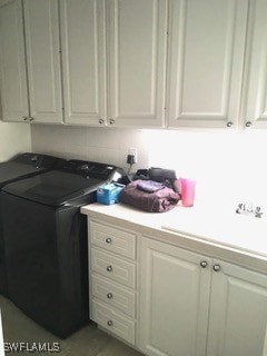 washroom featuring cabinets and washing machine and clothes dryer