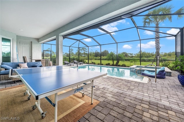 view of pool with a jacuzzi, glass enclosure, and a patio