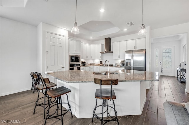 kitchen featuring stainless steel appliances, dark hardwood / wood-style floors, sink, and wall chimney range hood