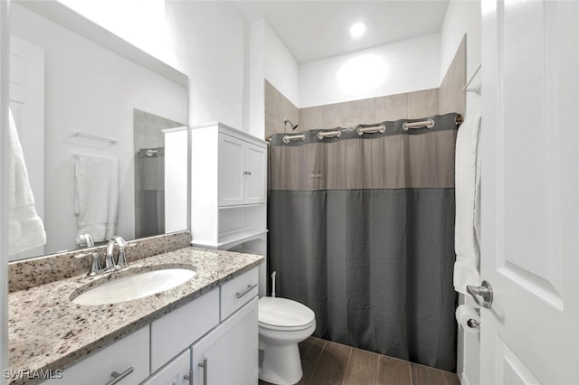 bathroom featuring wood-type flooring, vanity, toilet, and a shower with shower curtain