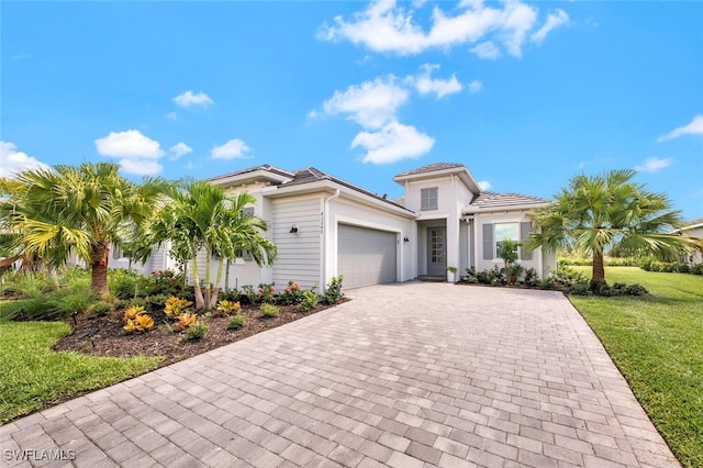 mediterranean / spanish-style home featuring a front yard and a garage