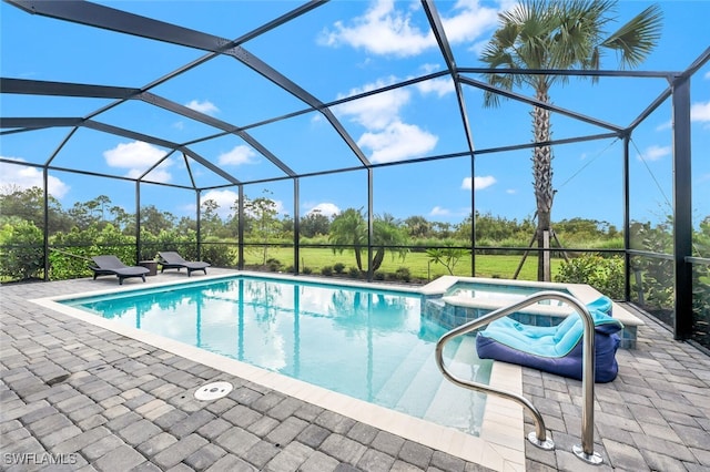 view of pool featuring a patio area, glass enclosure, and a pool with connected hot tub