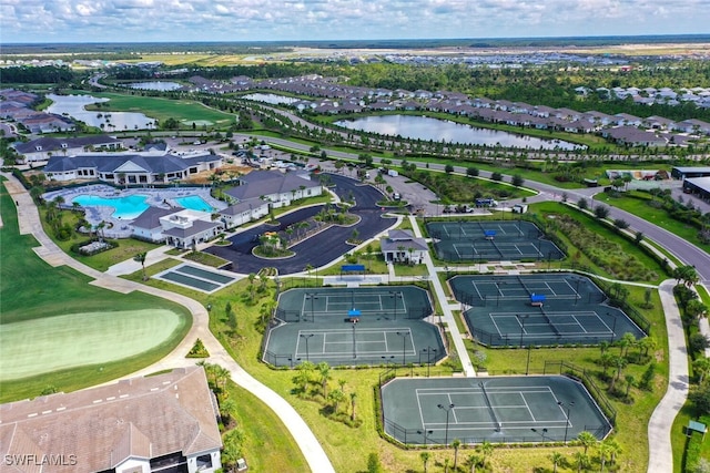 aerial perspective of suburban area with a large body of water, a pool, and a golf course