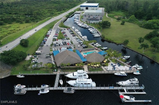 bird's eye view of a nearby body of water, numerous boat docks, and a heavily wooded area