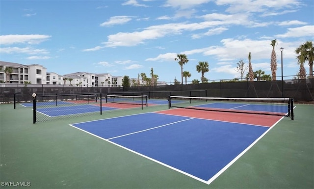 view of tennis court with community basketball court and fence