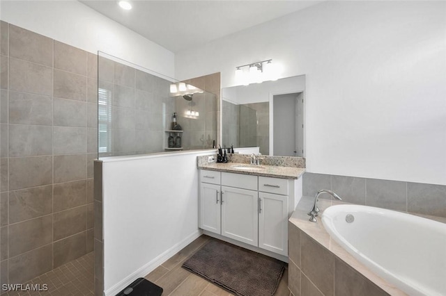 full bath featuring vanity, walk in shower, a bath, and wood finished floors