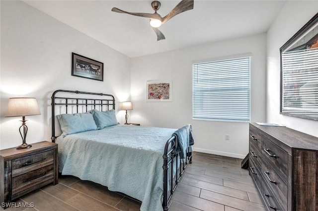 bedroom featuring wood tiled floors, baseboards, and a ceiling fan