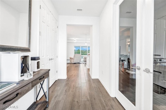 corridor with wood finished floors and baseboards