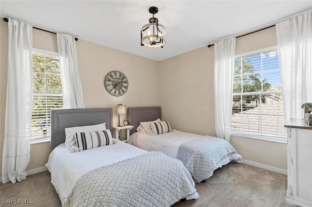 carpeted bedroom with a notable chandelier