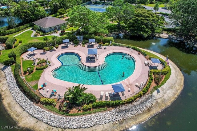 view of swimming pool with a water view and a patio area