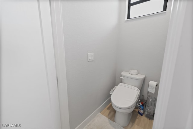 bathroom with hardwood / wood-style floors and toilet