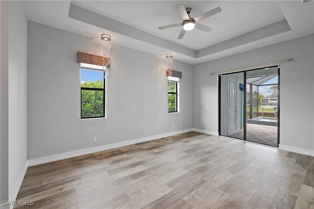 unfurnished room featuring ceiling fan, a healthy amount of sunlight, and light wood-type flooring