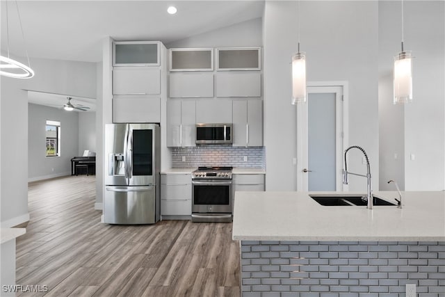 kitchen featuring pendant lighting, sink, wood-type flooring, and appliances with stainless steel finishes