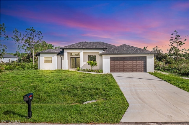 prairie-style house featuring a yard and a garage