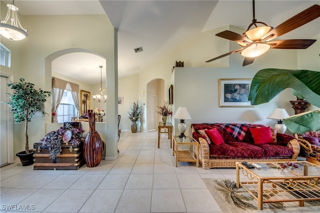 living room featuring ceiling fan with notable chandelier, vaulted ceiling, and light tile patterned floors