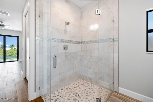 bathroom featuring walk in shower, wood-type flooring, and ceiling fan