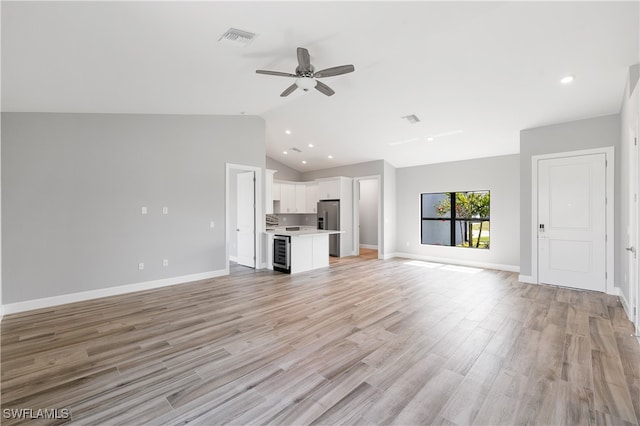 unfurnished living room featuring light wood-type flooring, lofted ceiling, beverage cooler, and ceiling fan