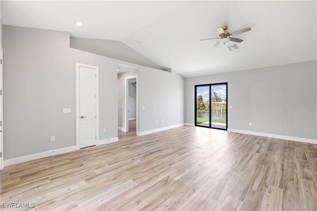 empty room with ceiling fan, lofted ceiling, and light hardwood / wood-style flooring