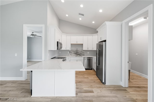 kitchen featuring white cabinetry, light hardwood / wood-style flooring, stainless steel appliances, light stone countertops, and ceiling fan