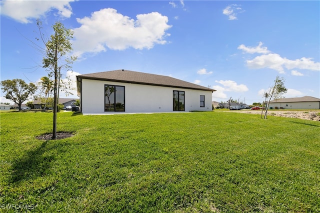 rear view of property with a yard