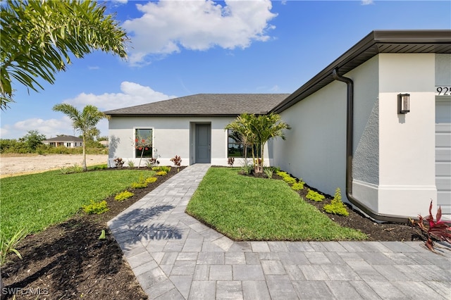 entrance to property featuring a lawn