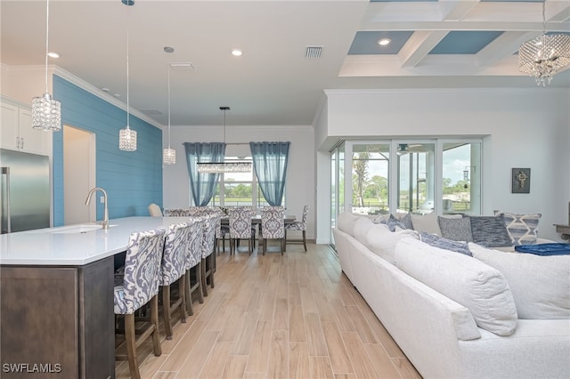 living room featuring crown molding, beamed ceiling, coffered ceiling, and light hardwood / wood-style flooring