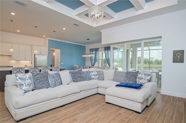 living room featuring light wood-type flooring, beam ceiling, and an inviting chandelier