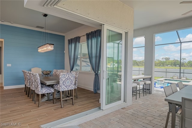 dining room with light hardwood / wood-style flooring, a wealth of natural light, ceiling fan, and crown molding