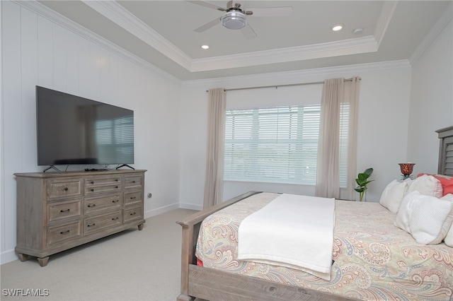 carpeted bedroom featuring ceiling fan, a tray ceiling, and ornamental molding