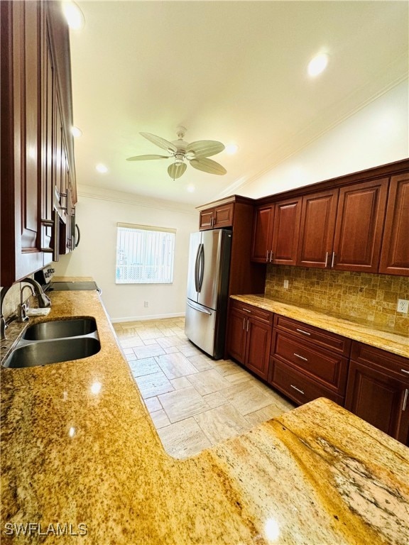 kitchen with stainless steel fridge, tasteful backsplash, crown molding, sink, and lofted ceiling