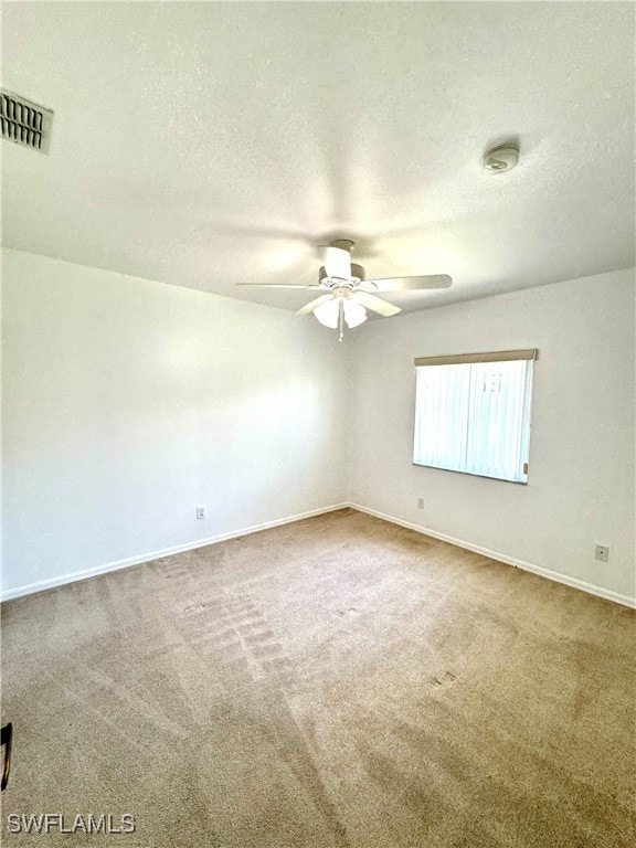 unfurnished room featuring ceiling fan, carpet floors, and a textured ceiling