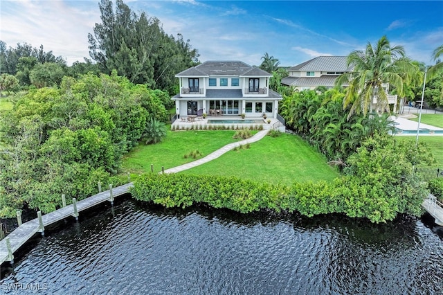 back of property featuring a lawn, a water view, and a patio